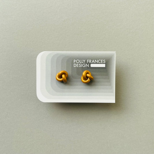 Gold Studs Sitting On Branded Polly Frances Design Card