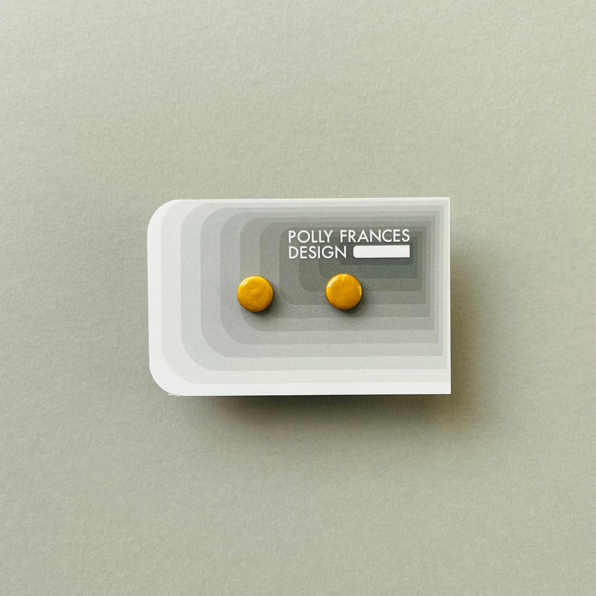 Gold Studs Sitting On Branded Polly Frances Design Card