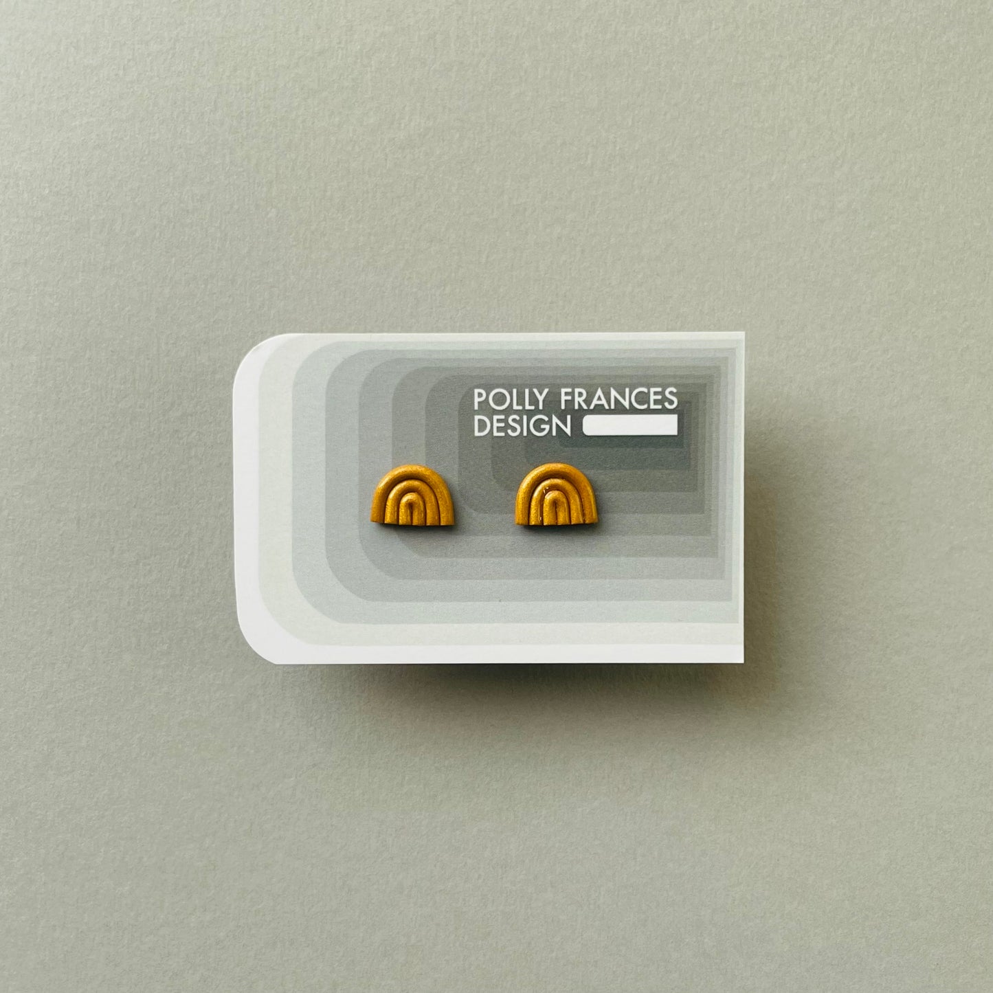 Gold Mini Arch Studs Sitting On Branded Polly Frances Design Card