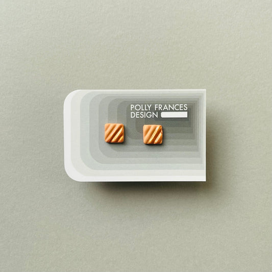 Gold Studs Sitting On Branded Polly Frances Design Card