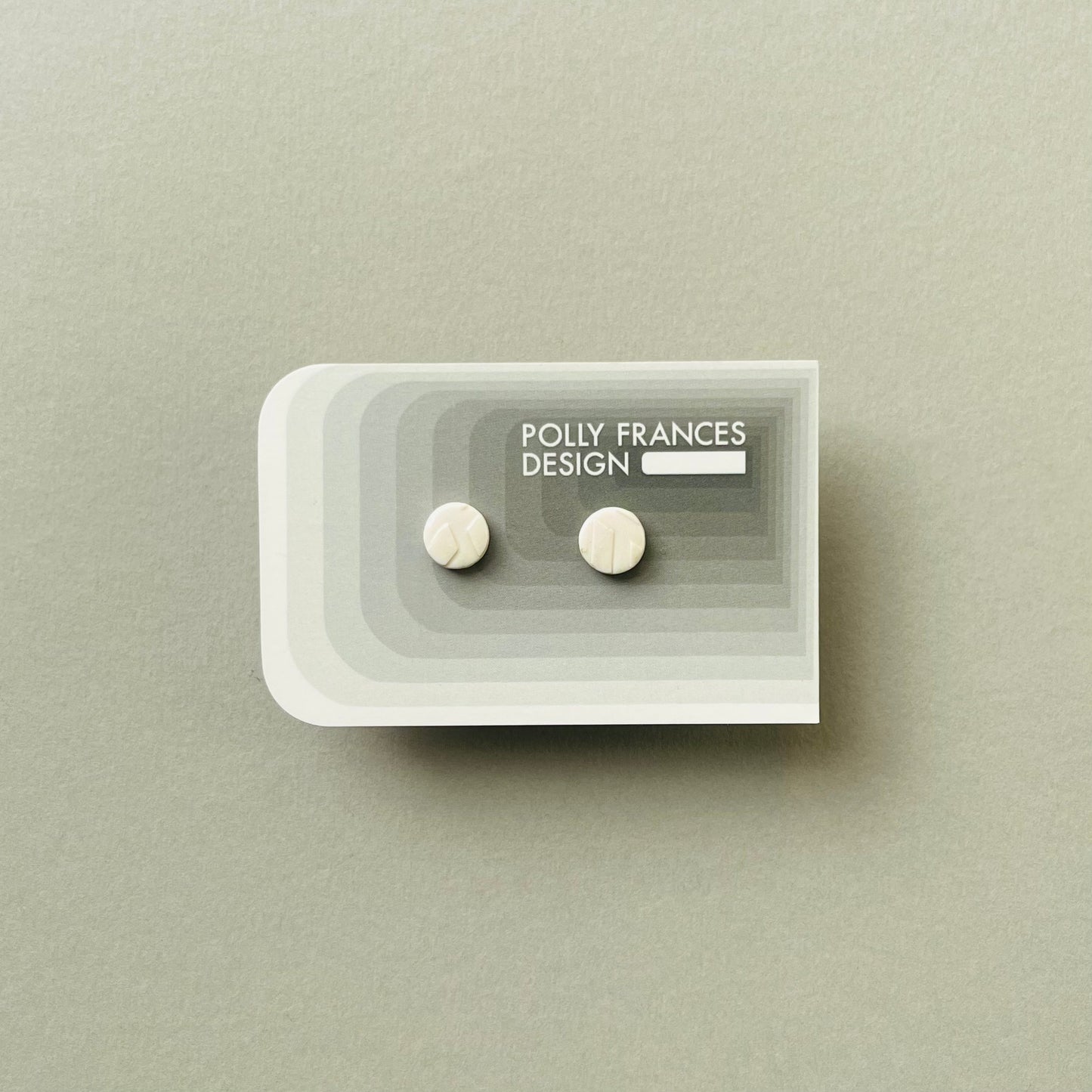 White Round Studs Sitting On Branded Polly Frances Design Card